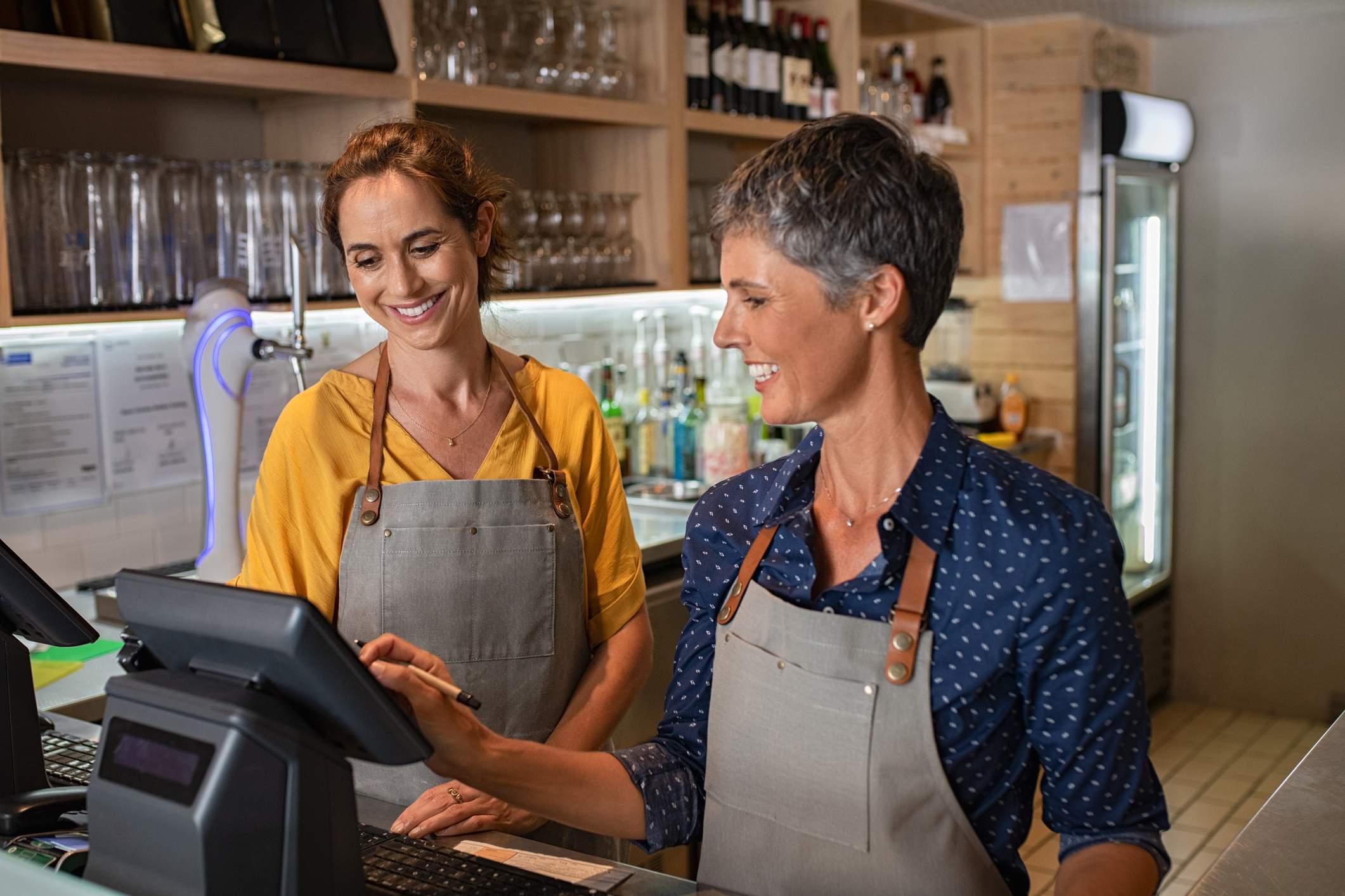 Image depicts two restaurant workers using their electronic ordering system.