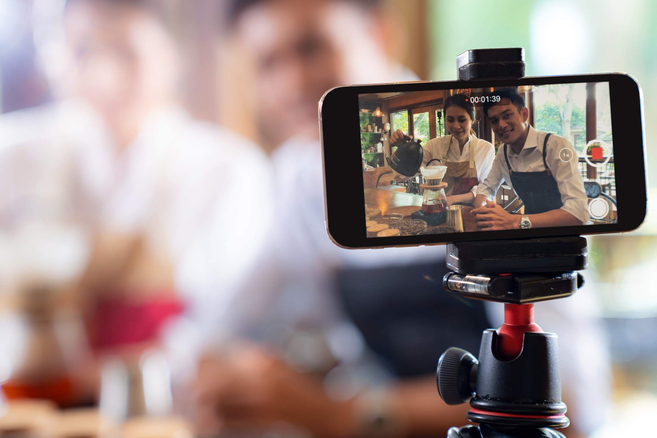 Image depicts two restaurant workers recording a video. 